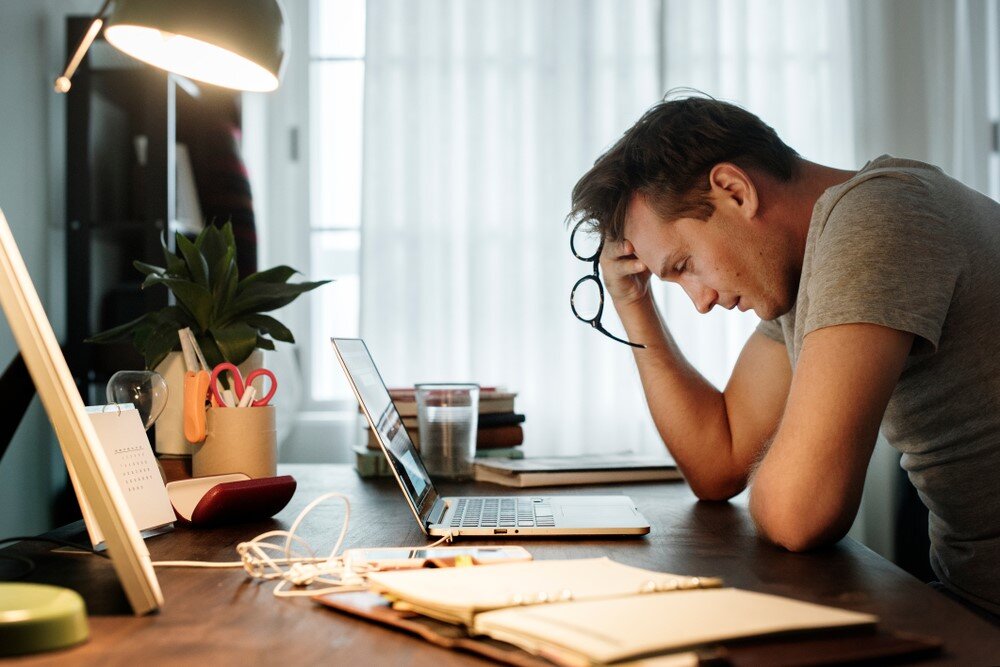 A man at the computer looking for a Hassle-Free Property Sale for out of state landlord