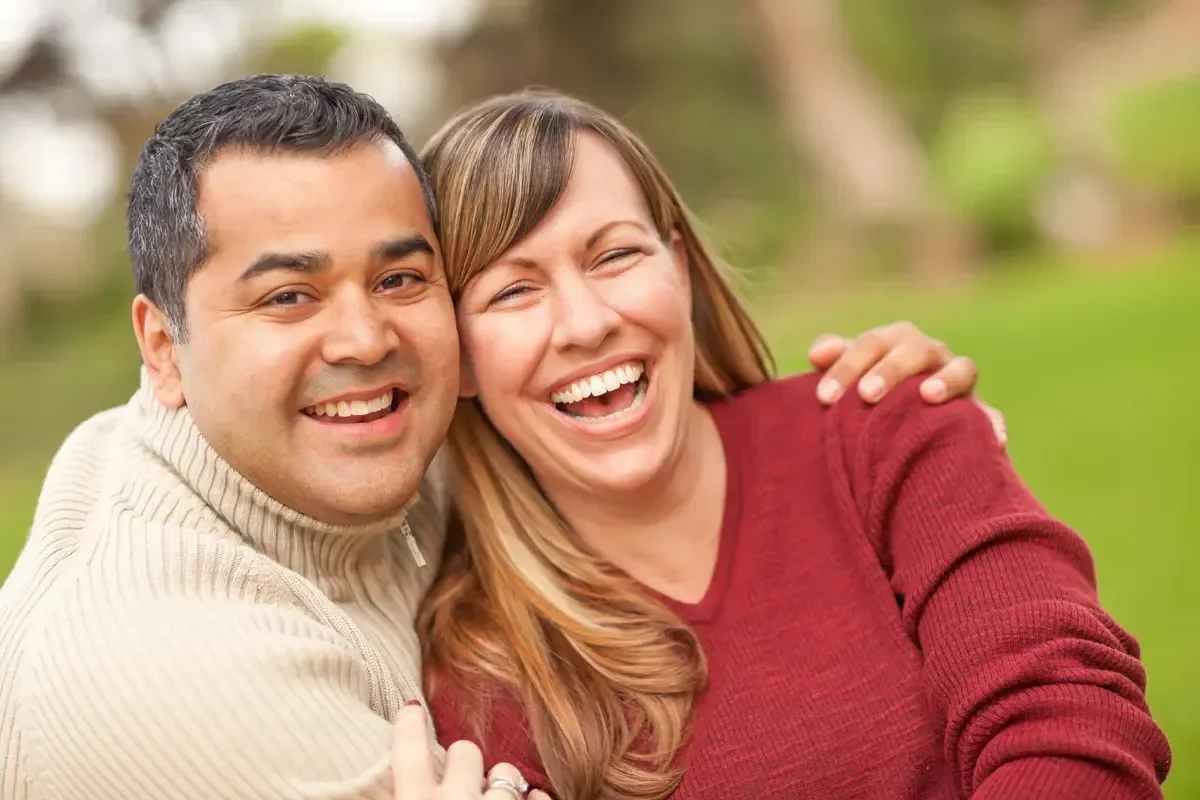 Happy couple smiling outdoors.