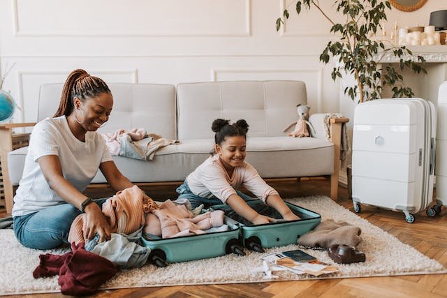 Mother and daughter packing clothes as they move.