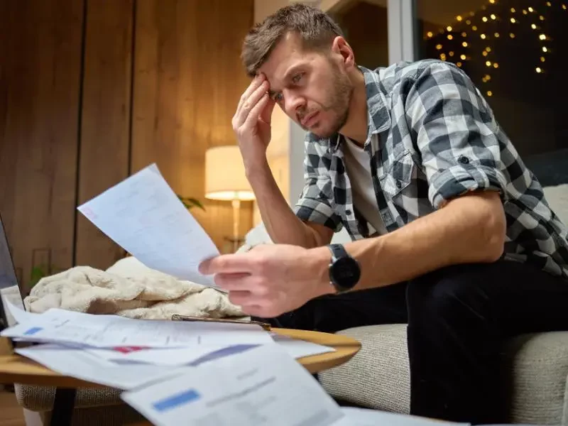 Stressed homeowner reviewing foreclosure documents in Oregon home