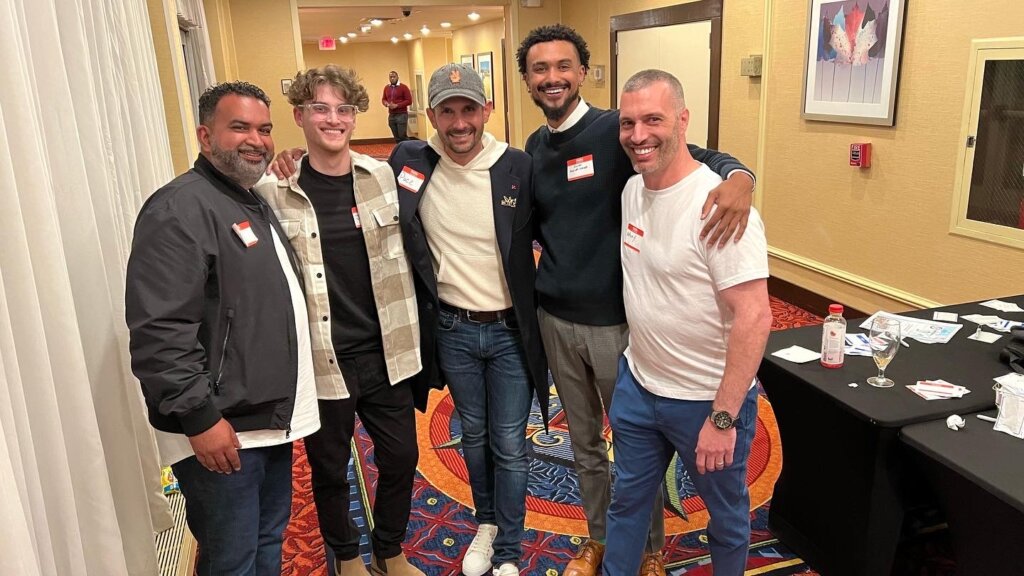 group of men smiling at a conference