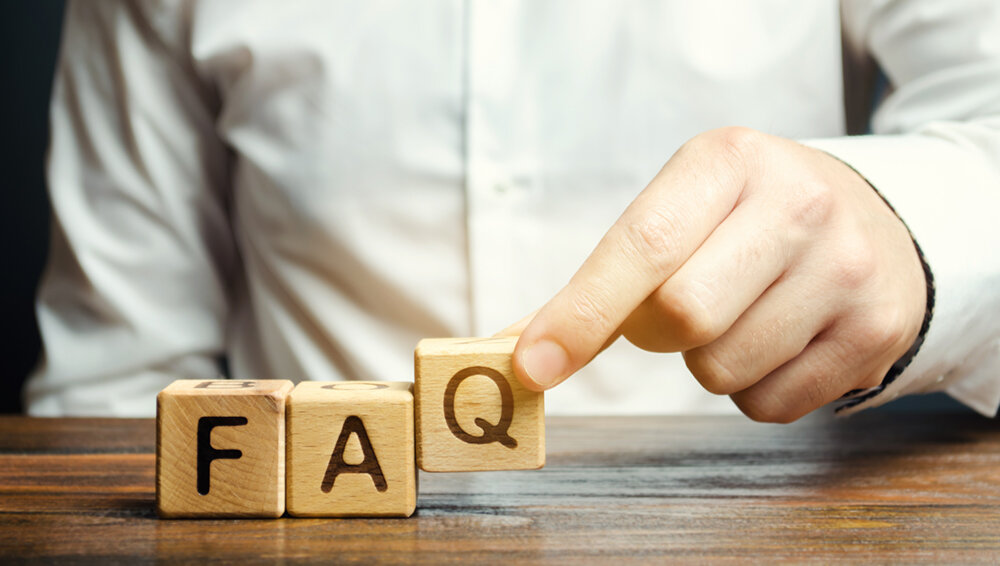 FAQ Section: Man stacks blocks to show FAQ letters