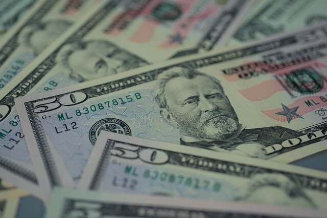 Dollar bills depicting the cost considerations involved in replacing a water heater.