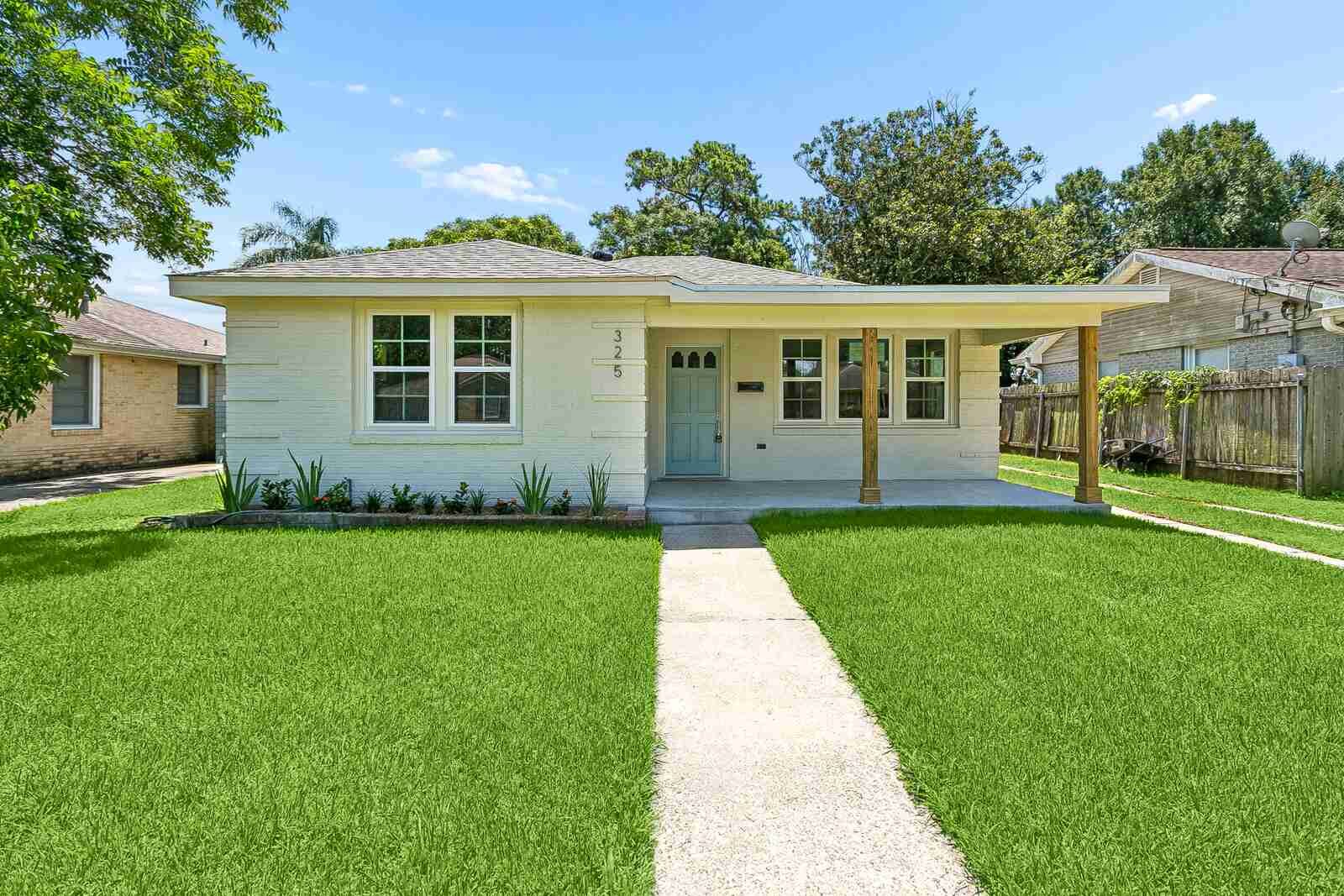 After: 325 N Bengal, Metairie — white-brick bungalow with sage front door renovated by Bertucci Investment Group cash home buyer