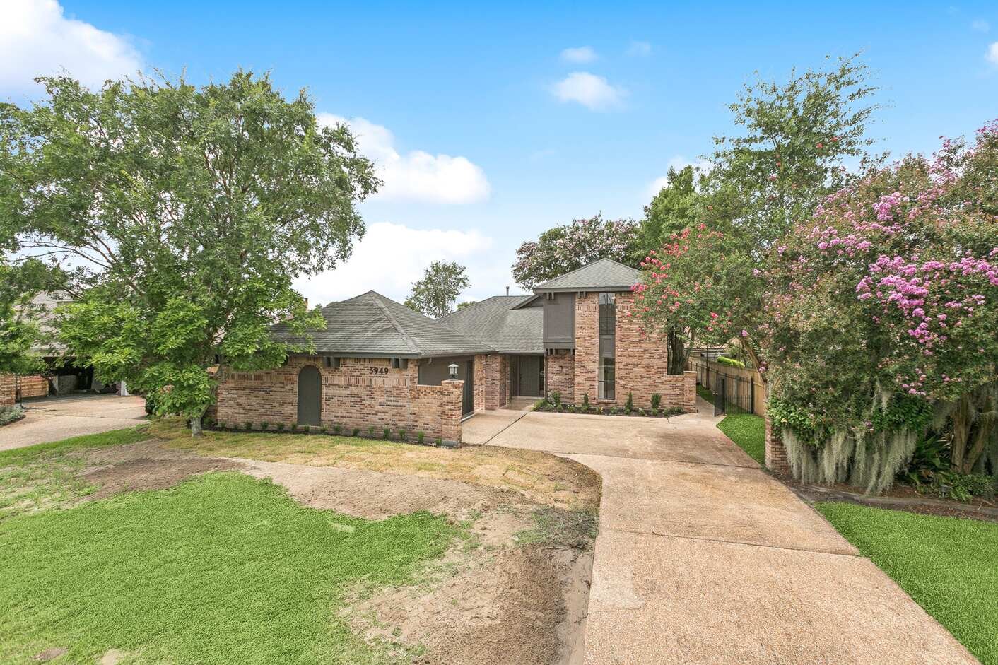 After: 3949 Lennox, Metairie — same brick front elevation renovated by Bertucci Investment Group with fresh landscape and crepe myrtles in bloom