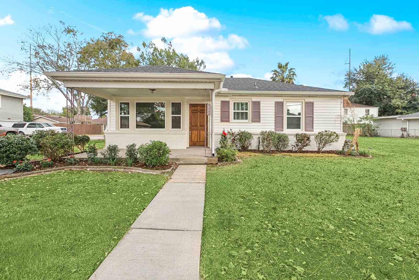 After: 621 Pasadena, Metairie LA — white clapboard bungalow with covered porch renovated by Bertucci Investment Group cash home buyer