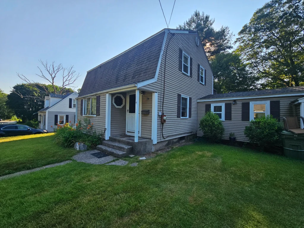 House on Browning Road in Somerville MA with peeling paint and distressed siding needing major repairs.
