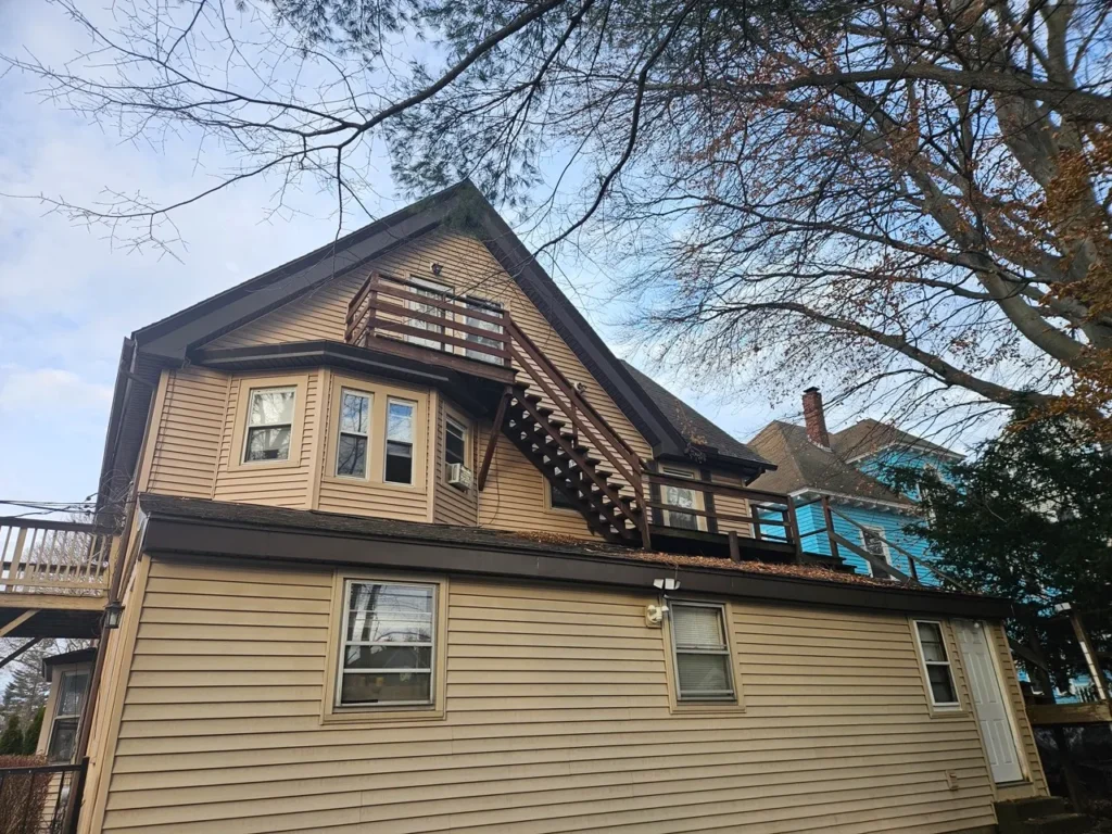 Exterior view of a large multi-family inherited property on Einhorn Road featuring an external wooden staircase.