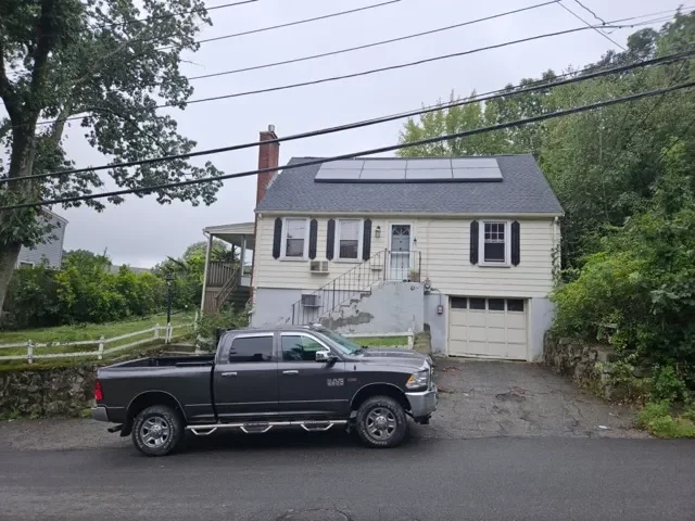Residential house on Elwell Street in Malden Massachusetts featuring a raised foundation and built-in garage.