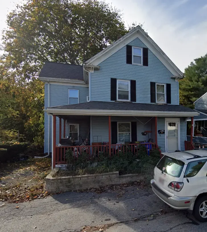 Blue single-family home on Traverse Street in Wakefield MA with a covered front porch needing exterior upkeep.