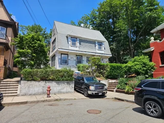 Inherited house on Browning Road in Somerville MA with peeling paint and distressed siding needing major repairs.