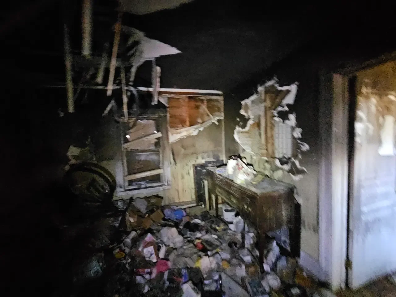 Fire-damaged room in a Worcester fixer-upper house with debris on the floor and ruined walls