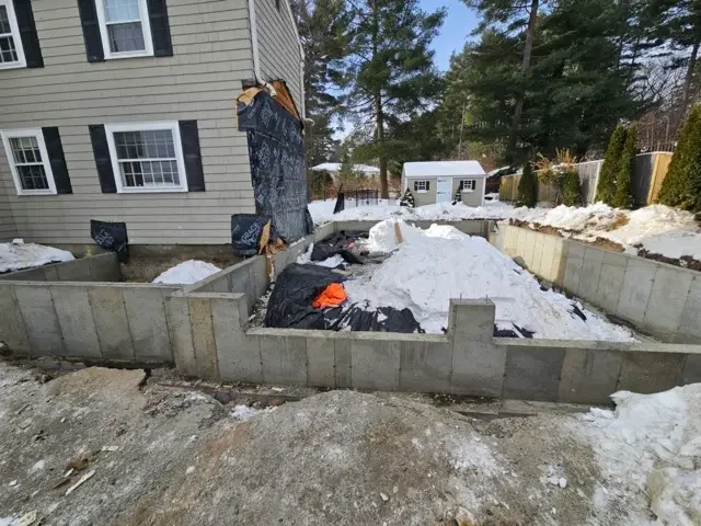 Exterior view of a home showing unpermitted construction work and open foundation footings