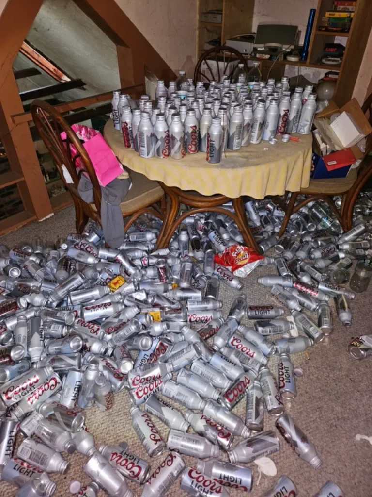 Dining room table and carpet covered with hundreds of empty beer cans in a MetroWest house with hoarding issues