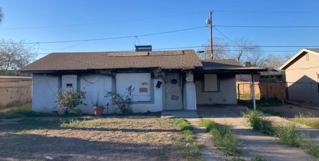 Fire-damaged home exterior in Phoenix with visible smoke and structural damage.