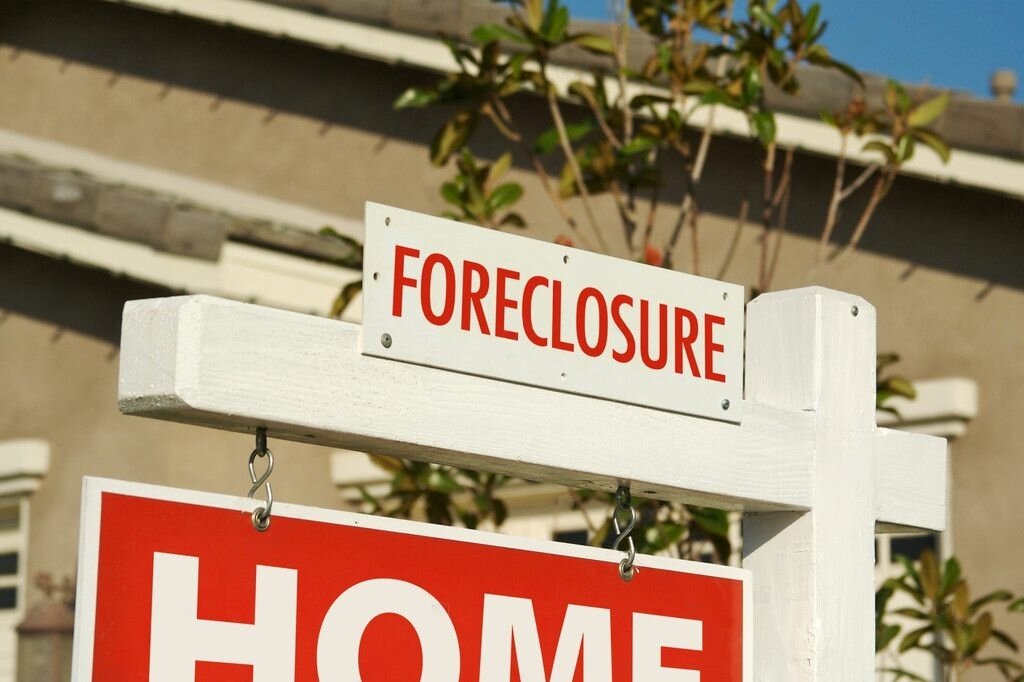 Desolate view of a home in Hollywood, FL, with foreclosure signs, symbolizing financial distress.
