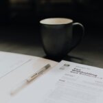 Coffee cup with tax papers for individuals wondering the tax implications of selling their southern Indiana home