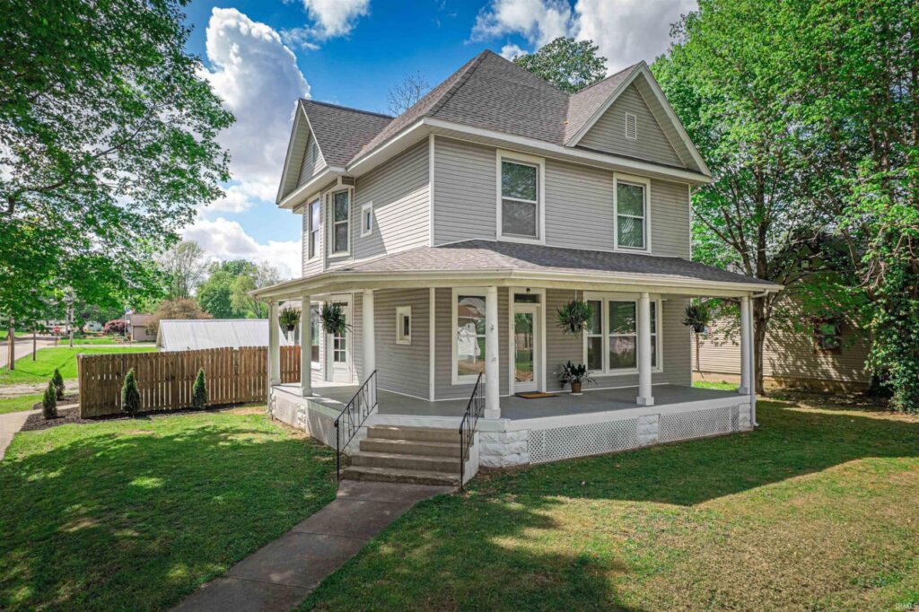 Charming gray Owensville home for sale with a wrap-around porch.