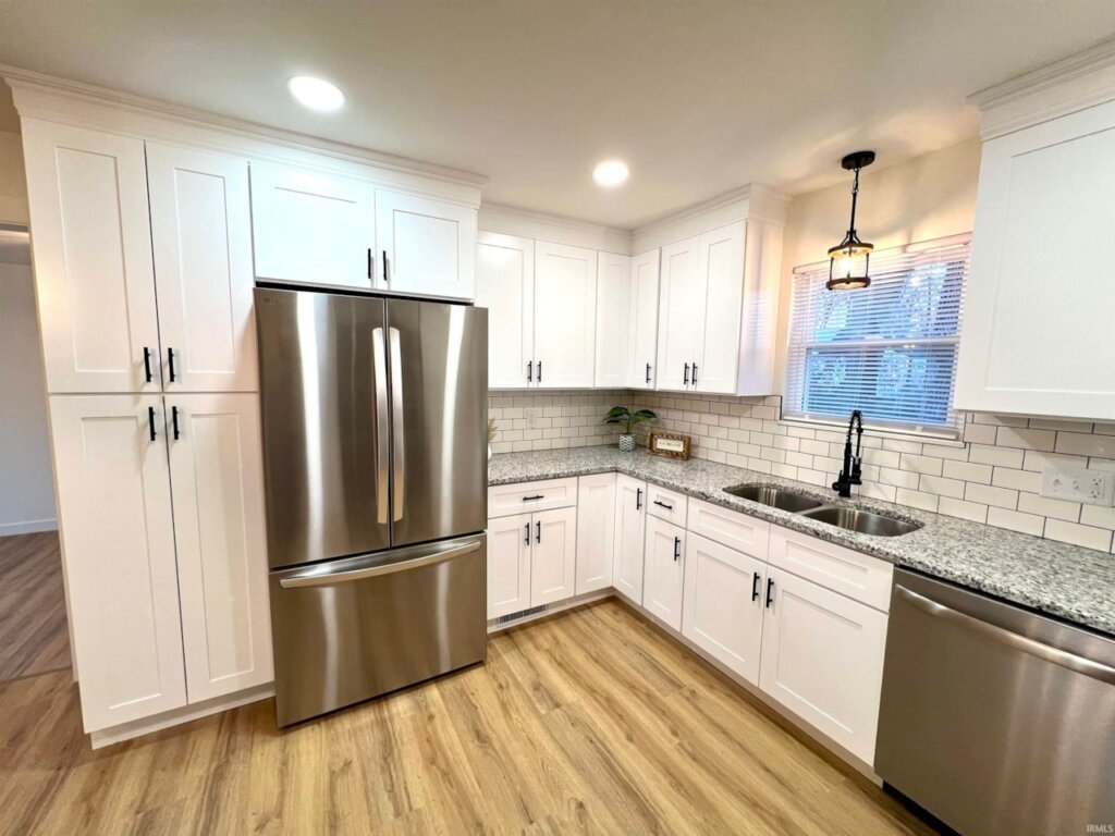Renovated kitchen with white cabinets and new stainless steel appliances in this Newburgh Indiana home for sale.