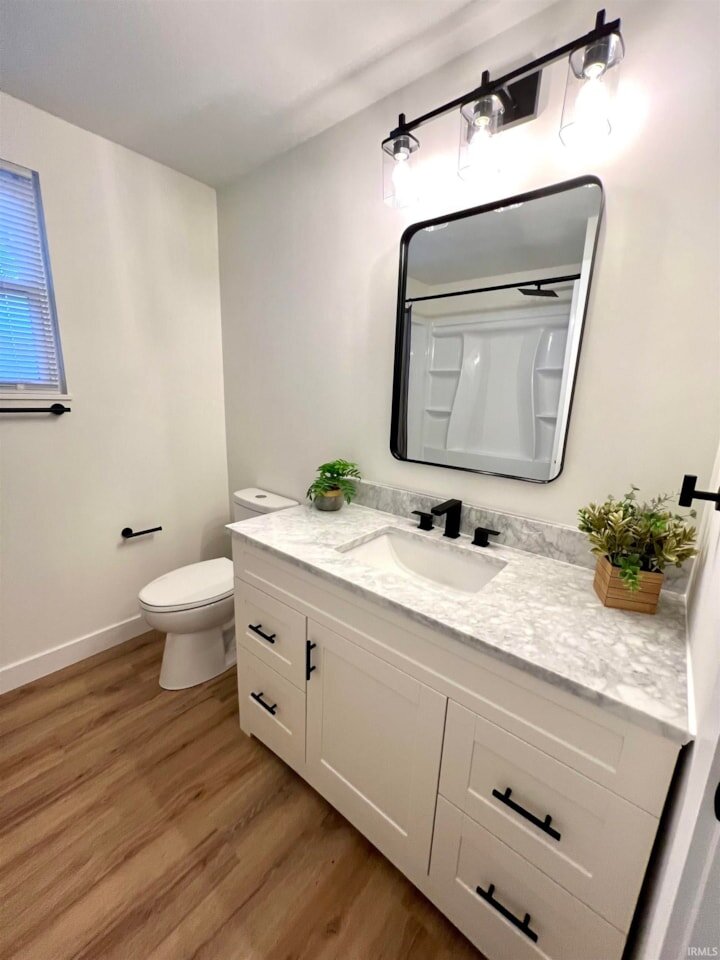 New bathroom updates in Newburgh Indiana home on Oaklawn Drive for Sale. Vanity has a gray counter top with black fixtures.