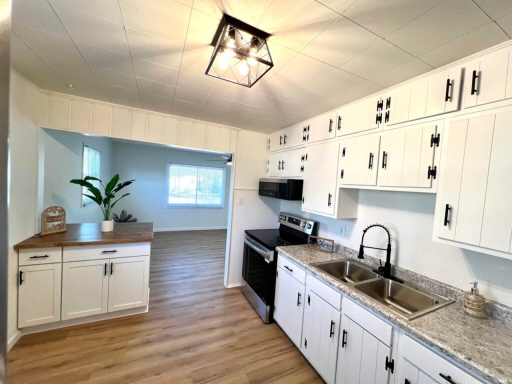 Kitchen with white cabinets and a light brown counter top in Ravenswood, IN home for sale.