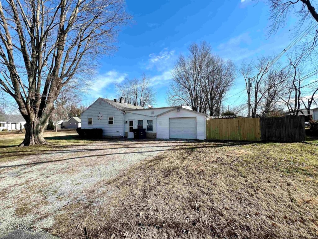 Outside view of home, garage, and fenced-in back yard of home for sale in Evansville.