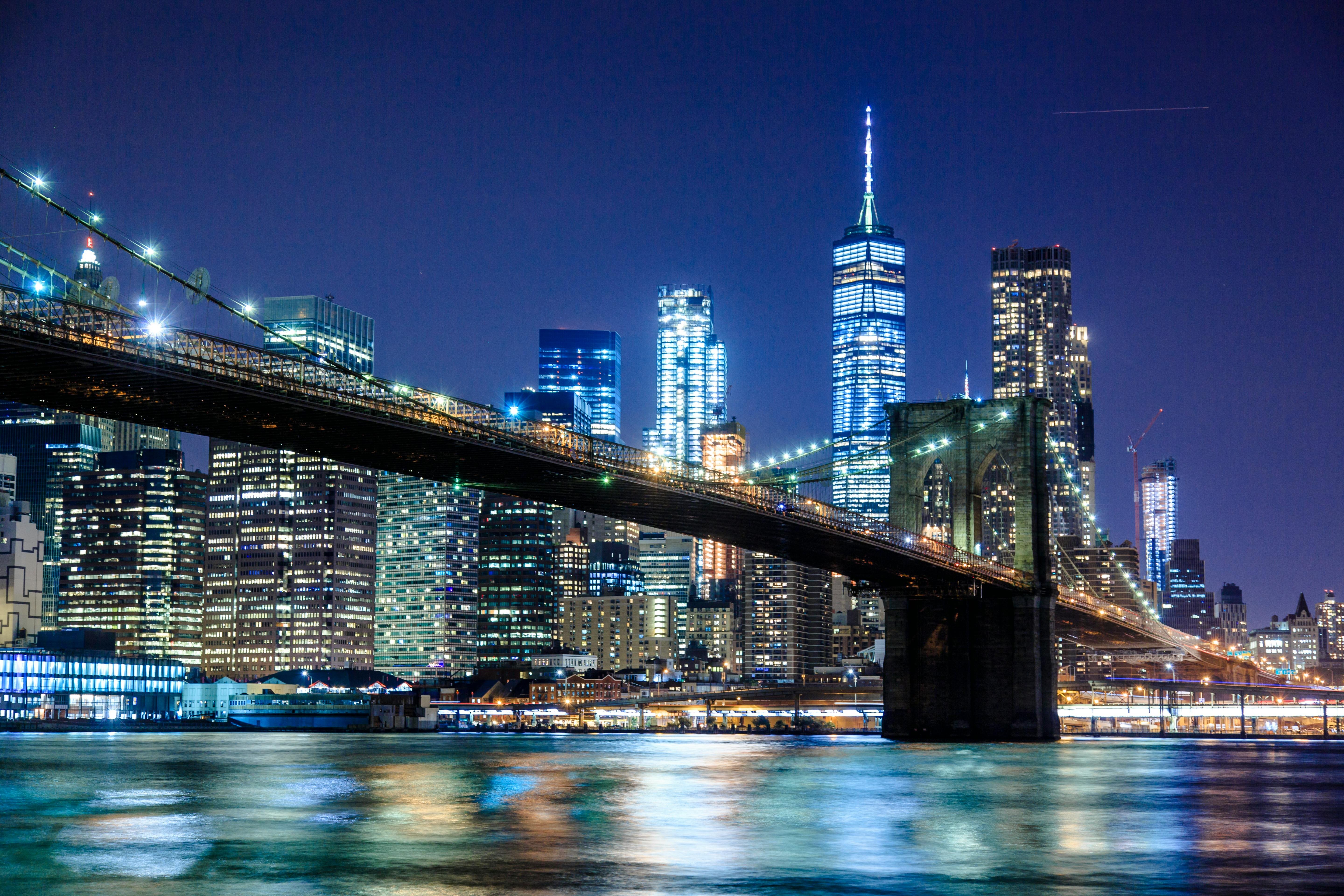 New York City skyline at night featuring the brightly lit Empire State Building and surrounding skyscrapers.