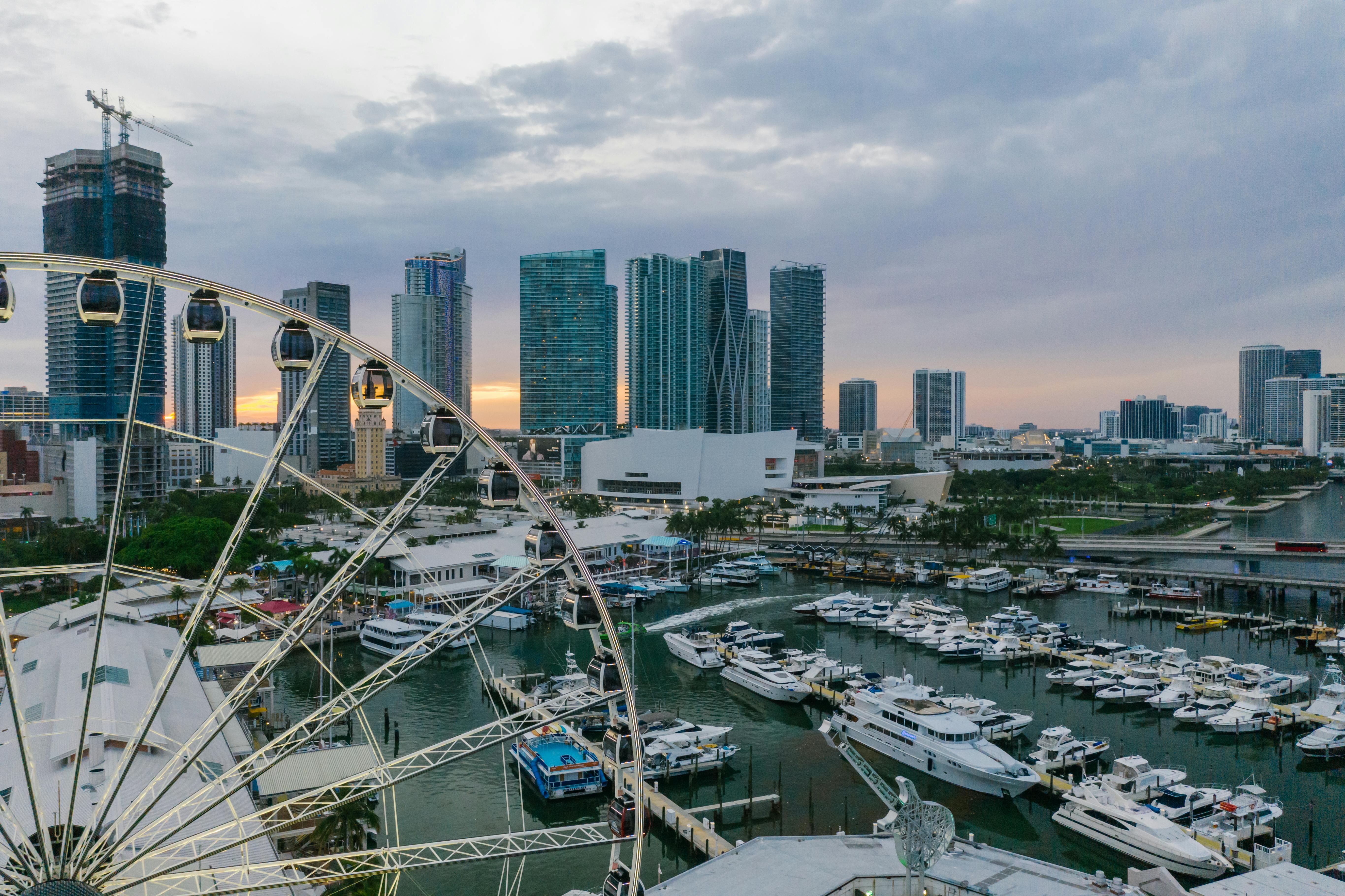 Modern city buildings under a colorful sunset with vibrant clouds in the sky.
