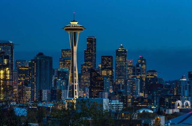 A night view of Seattle's skyline with the iconic Space Needle in the foreground.