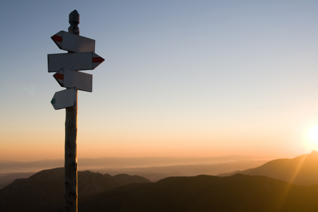 "Signpost at sunrise offering direction for selling a home in Ohio with scenic background"