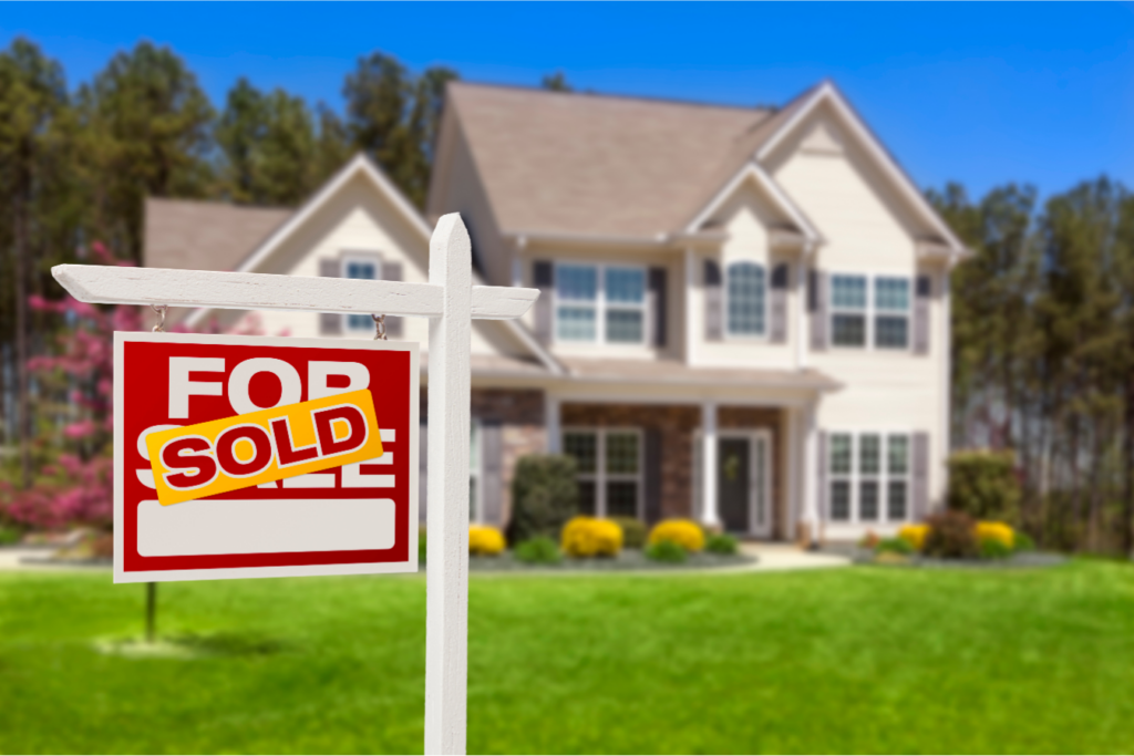 Newly sold spacious suburban Ohio home in spring with a vibrant green lawn, showcasing a bright 'For Sold' sign, symbolizing a successful real estate transaction in a seller's market.