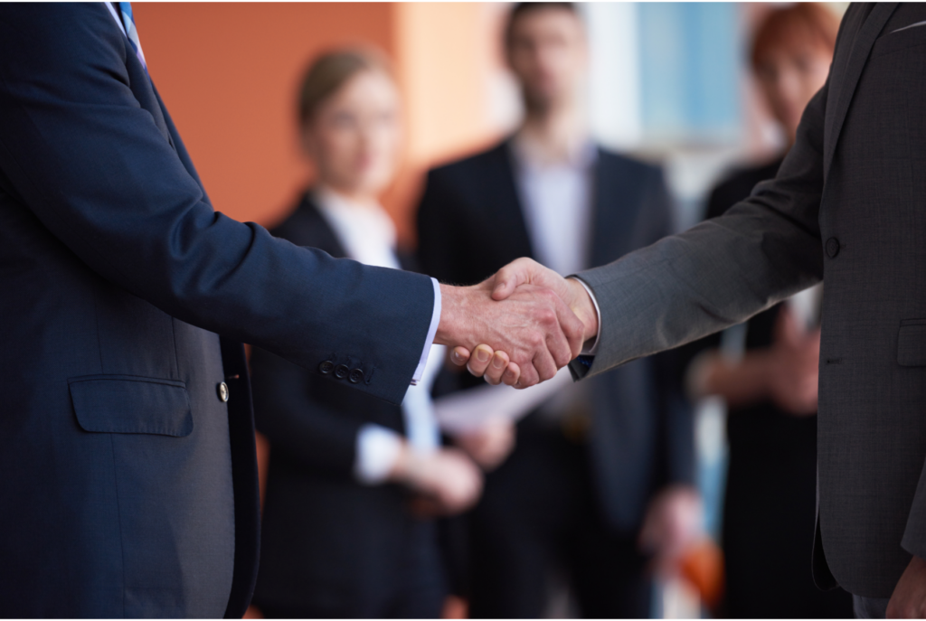 Two professionals shaking hands in agreement, symbolizing a successful partnership in navigating the sale of a house with delinquent taxes in Ohio.