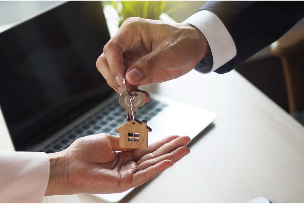 Real estate agent handing over new house keys to homeowner after closing in Ohio