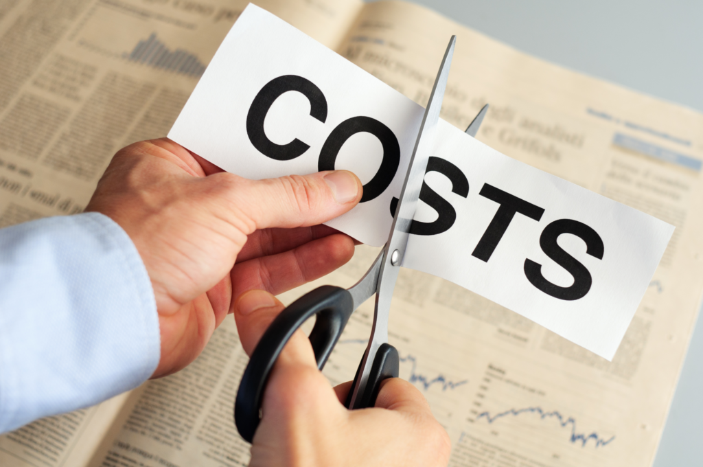 Cutting COSTS text with scissors over financial newspaper, concept for saving on home selling in Cincinnati.