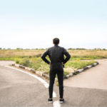 Man contemplating which path to take at a crossroads, symbolizing the decision to choose the right realtor in Ohio for selling a house.