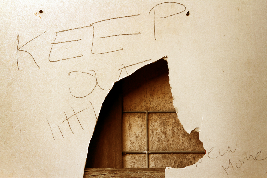 Keep Out sign on a broken wooden surface indicating a squatter's presence in an Ohio property.