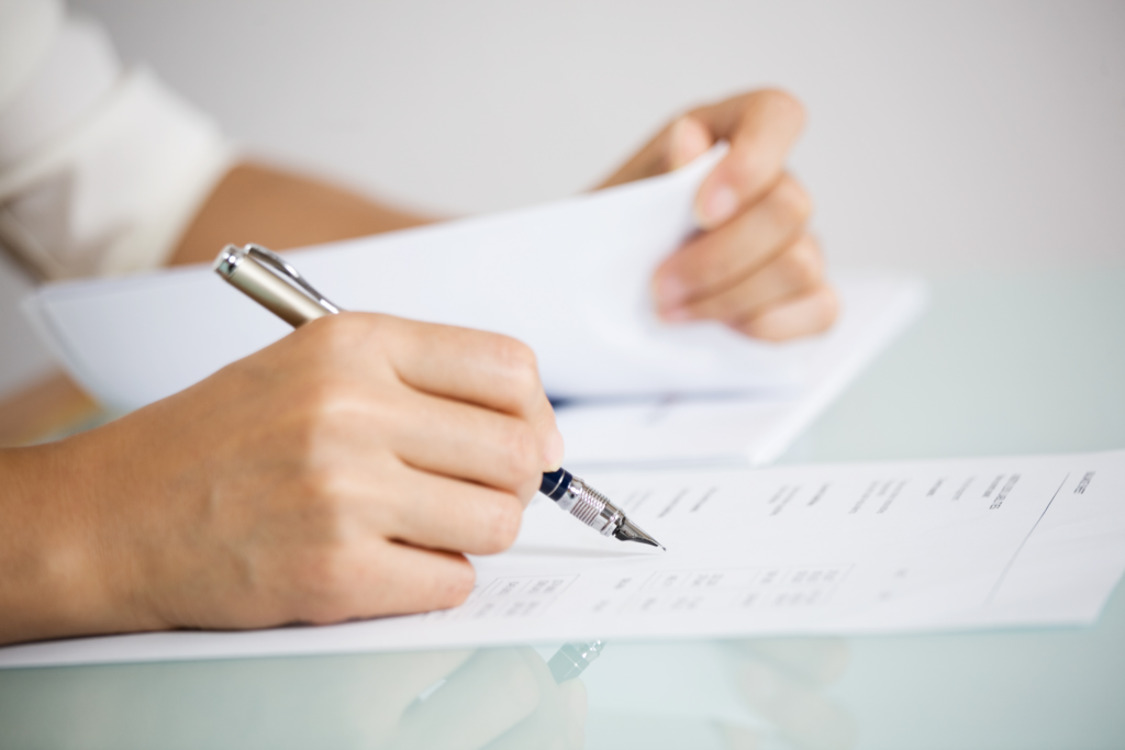 Homeowner in Ohio filling out necessary FSBO paperwork for house sale.