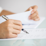 Homeowner in Ohio filling out necessary FSBO paperwork for house sale.
