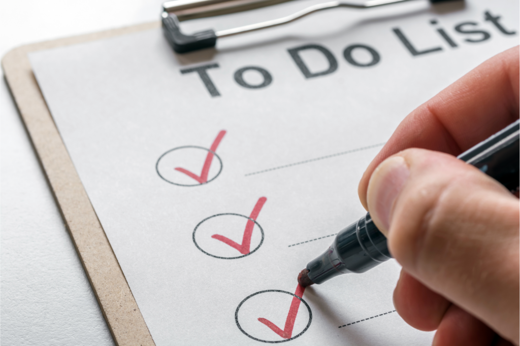 Hand ticking off items on a 'To Do List' clipboard, representing the key steps in preparing a house for a fast sale in the Ohio real estate market."