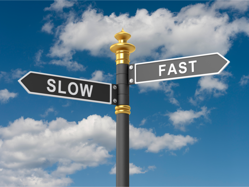 Directional signpost with 'Slow' and 'Fast' arrows against a cloudy sky, symbolizing quick vs slow house selling options in Ohio.