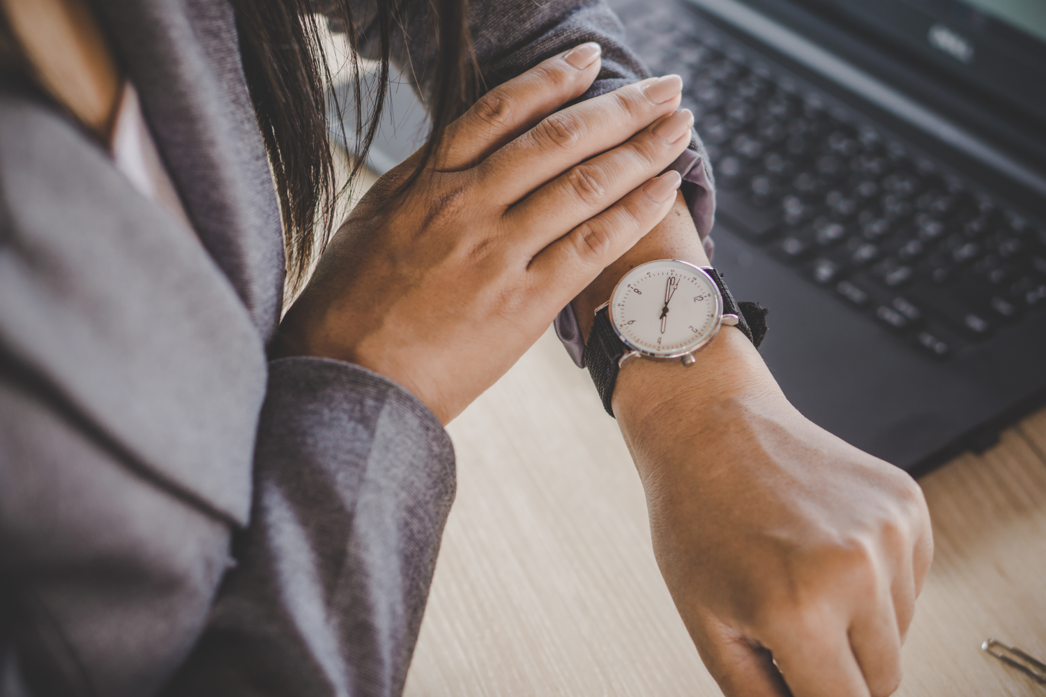 Professional woman checking the time on her watch, planning the best season to sell property in Ohio.
