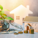 Saving money on Akron home sales with coins, house models, and growing plant representing financial growth.