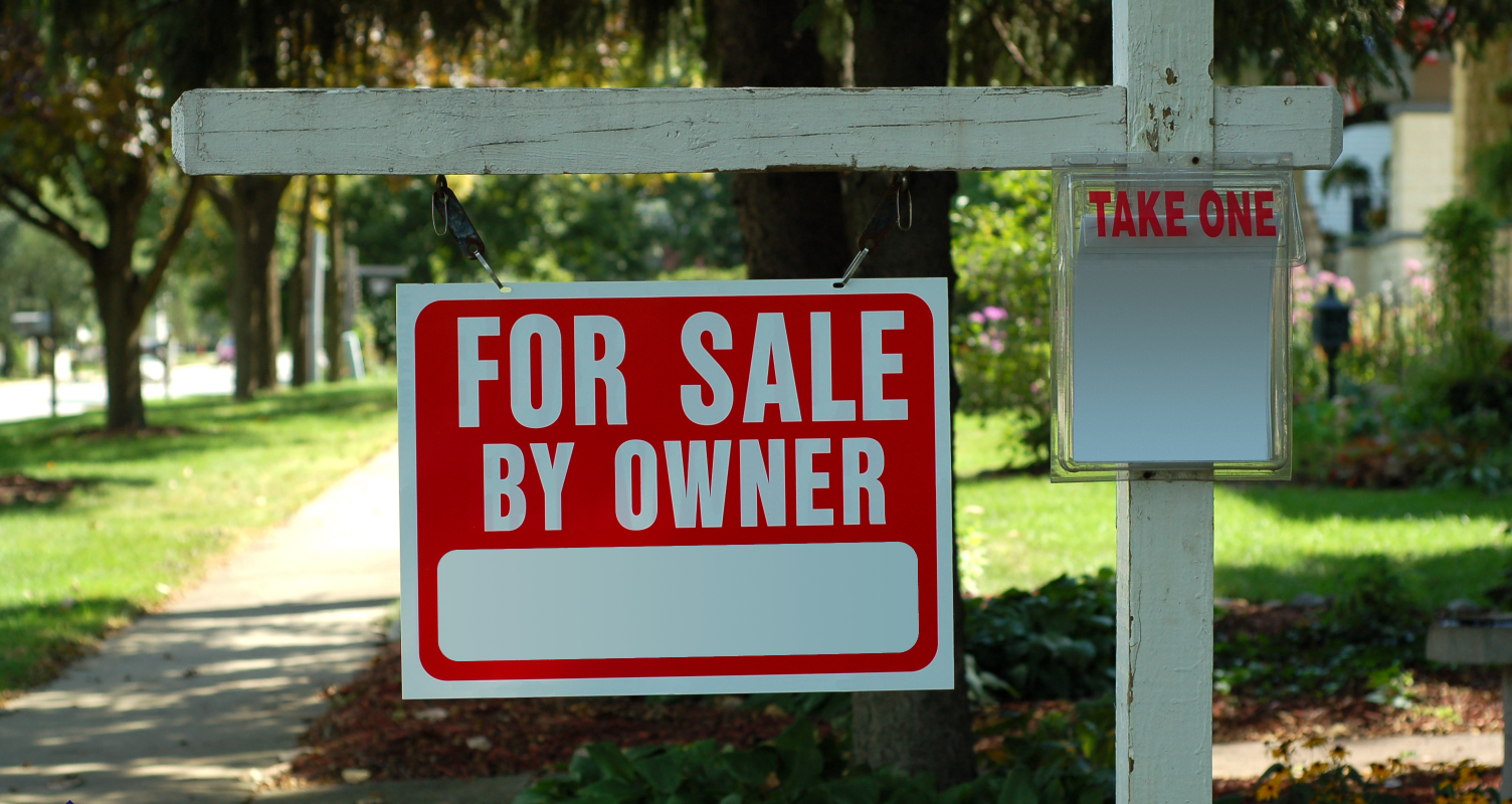 FSBO sign with flyers on a residential Cleveland street, inviting direct homebuyer inquiries