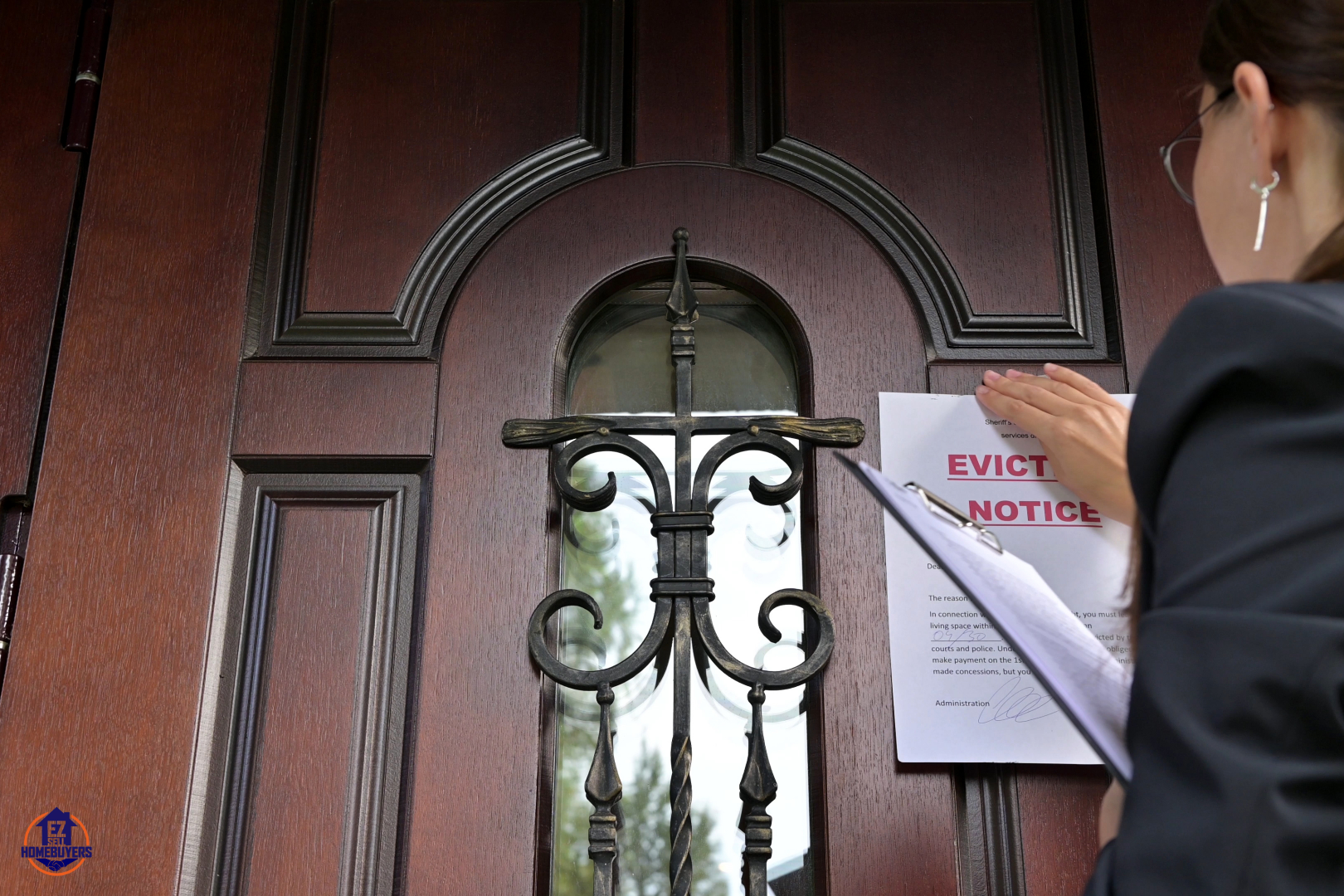 Property manager posting an eviction notice on a house door in Dayton, Ohio for squatter removal.
