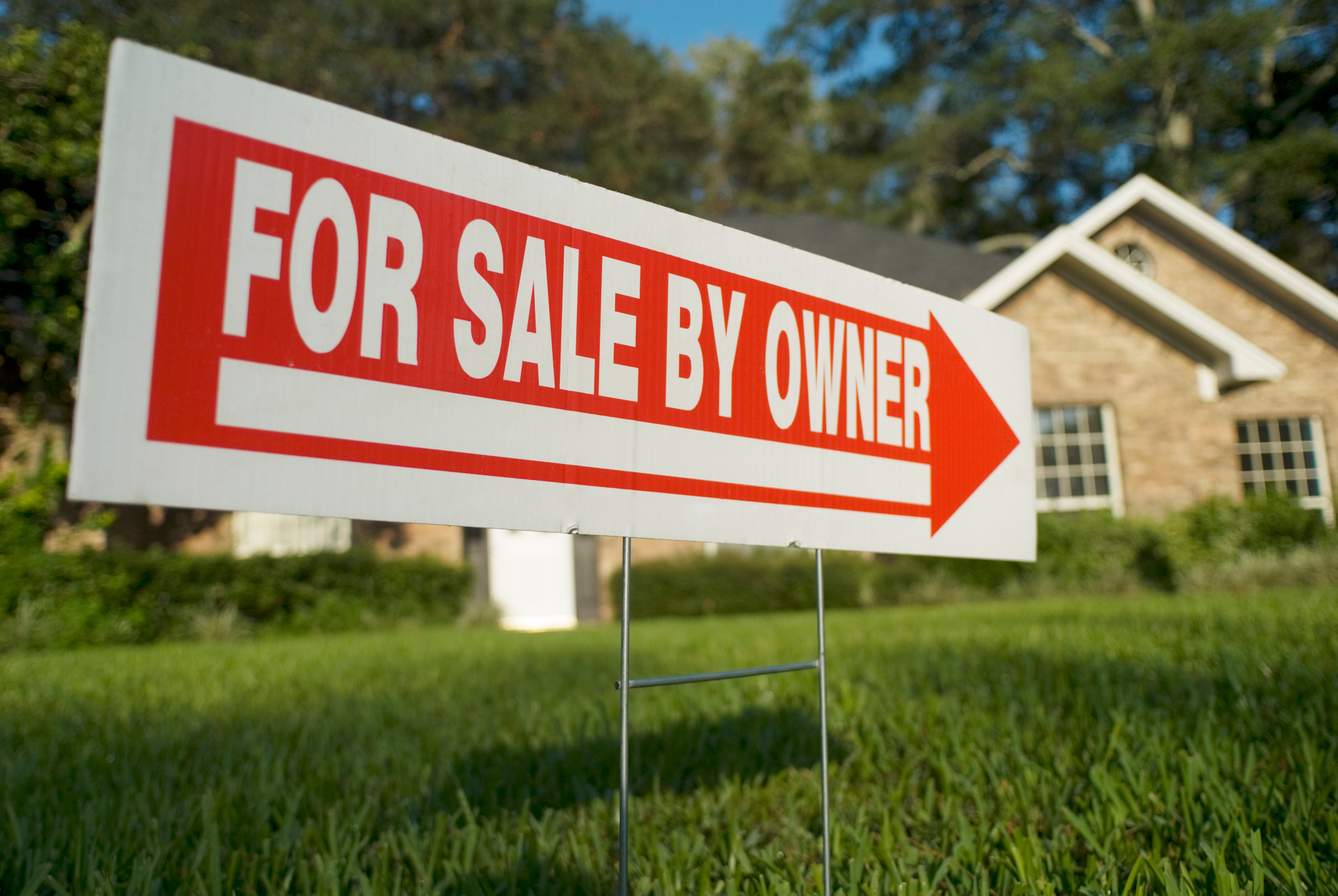 FSBO sign on front lawn indicating house for sale by owner in Dayton suburb