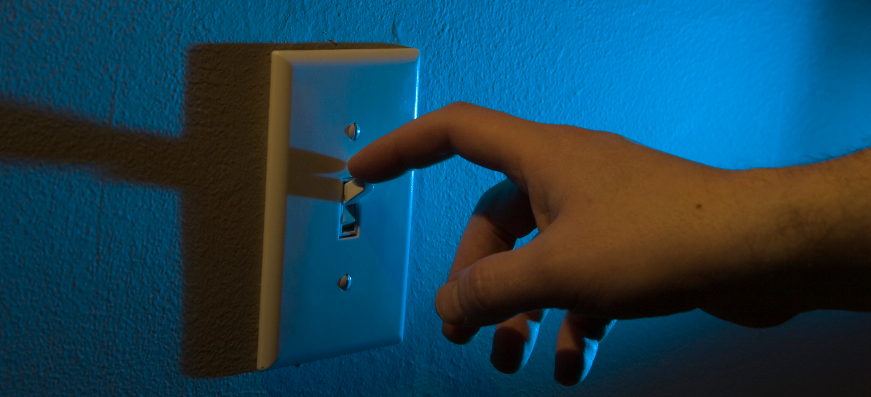 Landlord turning off light switch, illustrating utility shutoff laws in Ohio