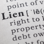 Close-up view of a dictionary definition of 'lien', illustrating the legal right to keep property because of debt, relevant to selling homes with liens in Cleveland.