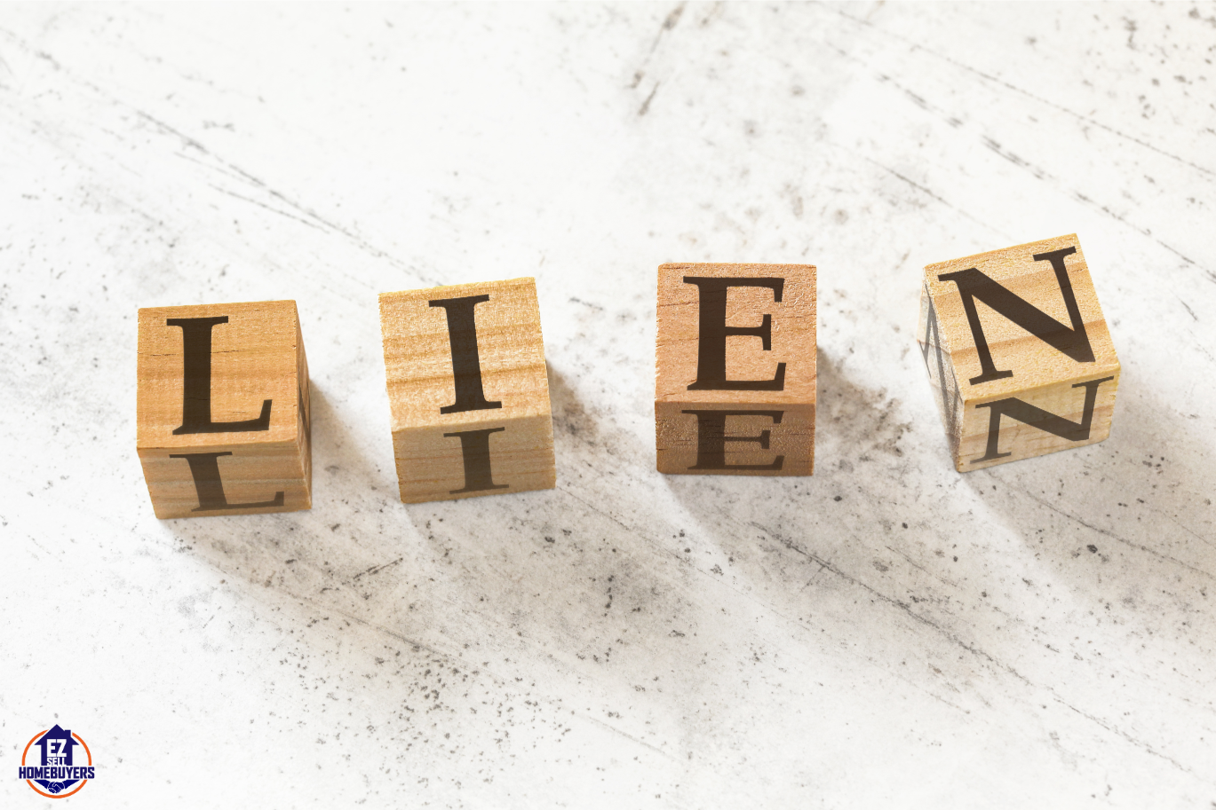 SEO-optimized alt text for this image could be: "Wooden blocks spelling LIEN on a marble surface, symbolizing Medicaid liens on property for an article about selling houses with Medicaid liens in Ohio."