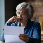 Senior woman reading Medicaid rules for selling home in Ohio, contemplating real estate decisions