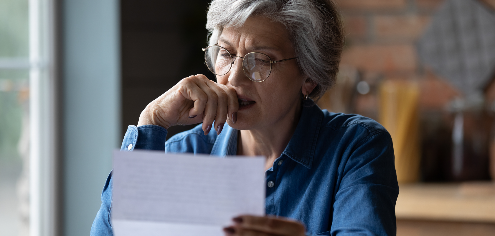 Senior woman reading Medicaid rules for selling home in Ohio, contemplating real estate decisions